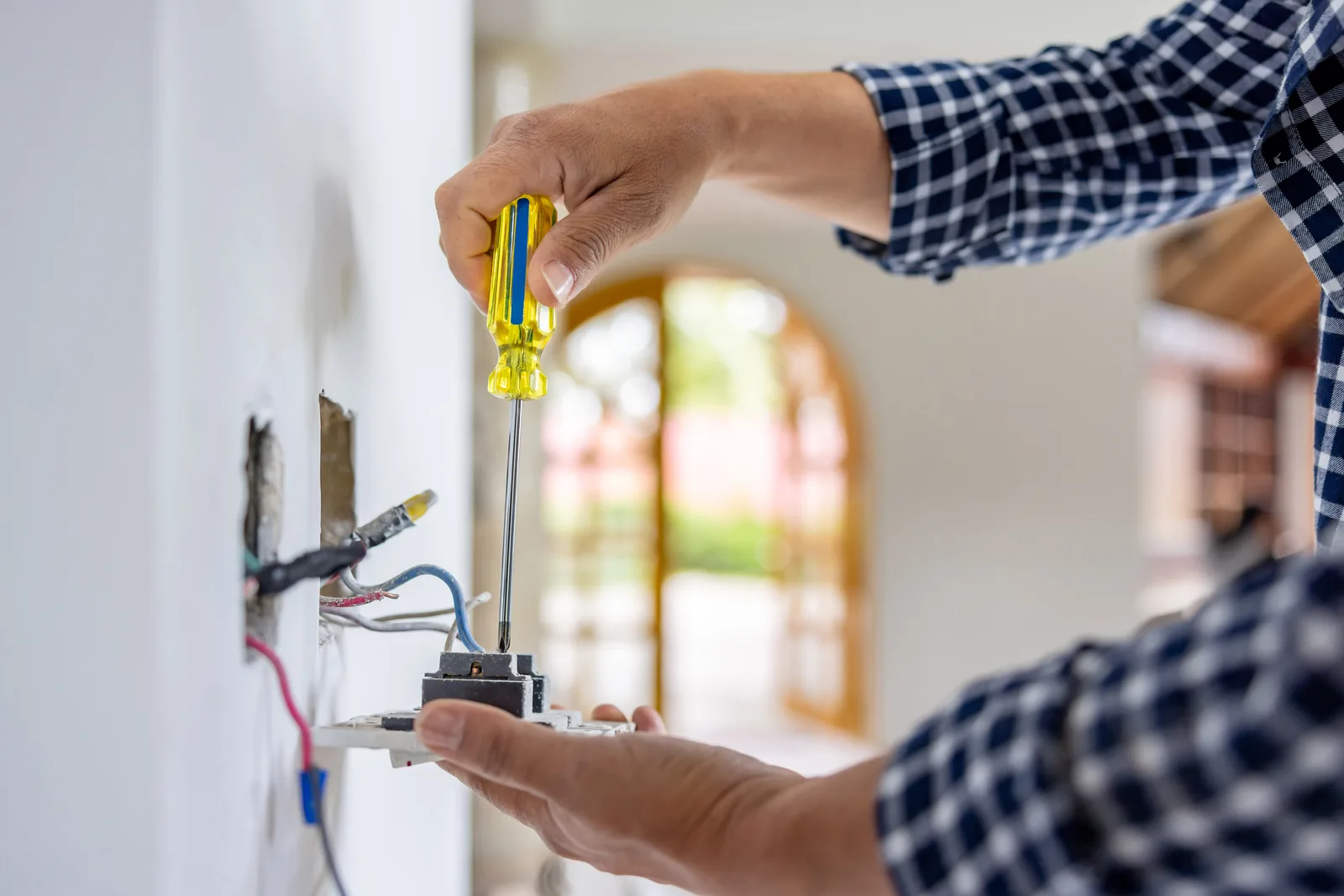Electrician wiring a wall power socket